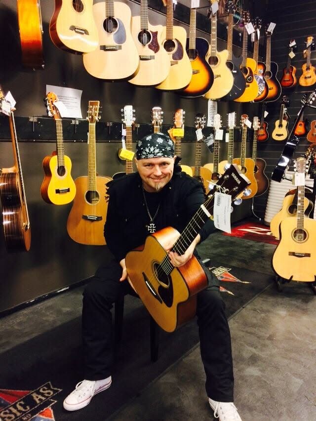 Alf Arne Hammer med gitar foran veggen
